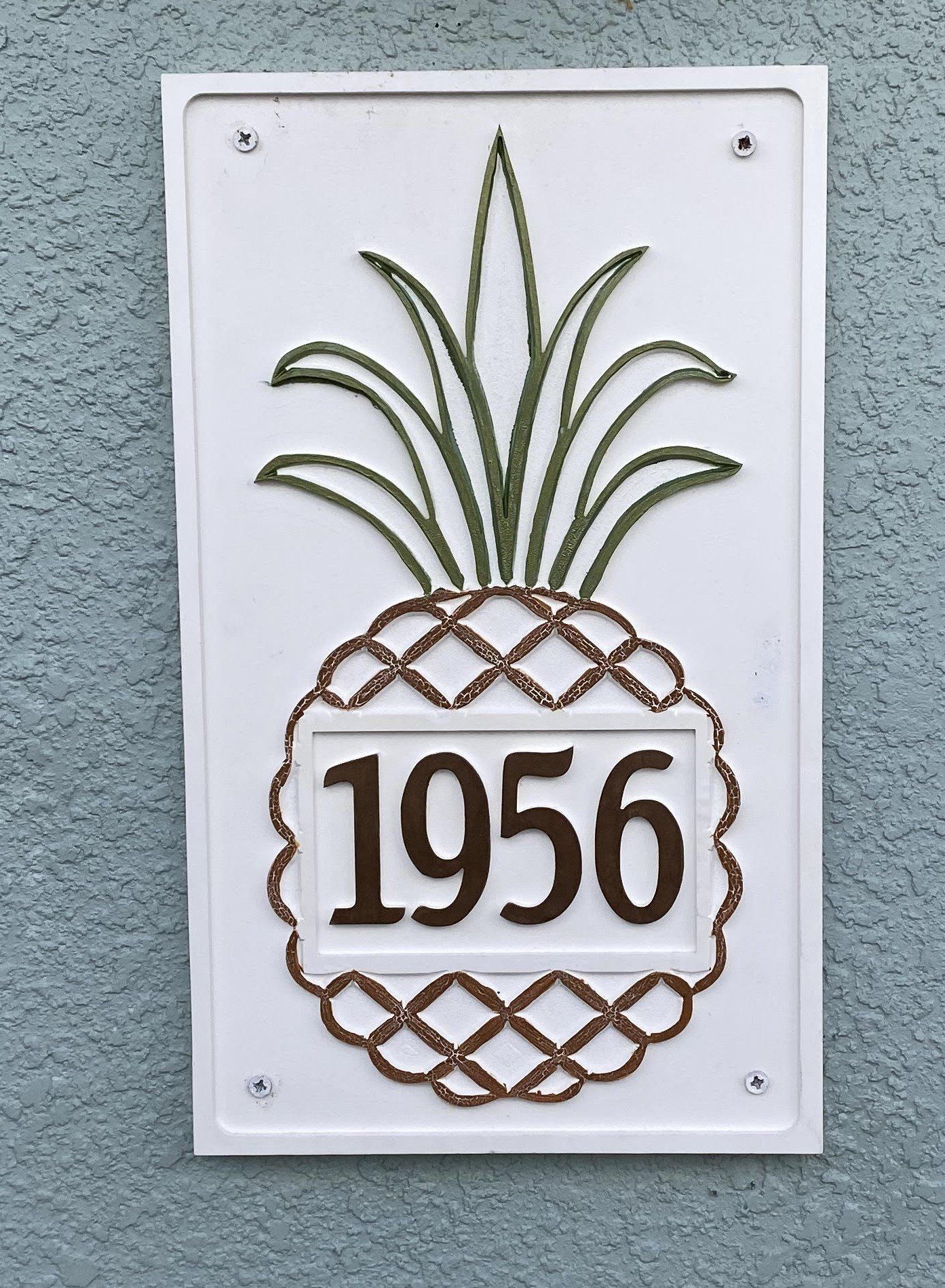 White sign with pineapple design and the number 1956