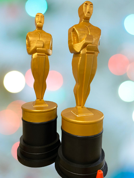 Two gold Oscar-style statuettes made from foam