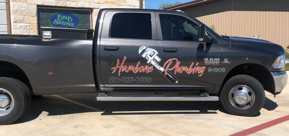 Black pickup truck with “Harris Roofing” logo and company text on the side, parked in a driveway.