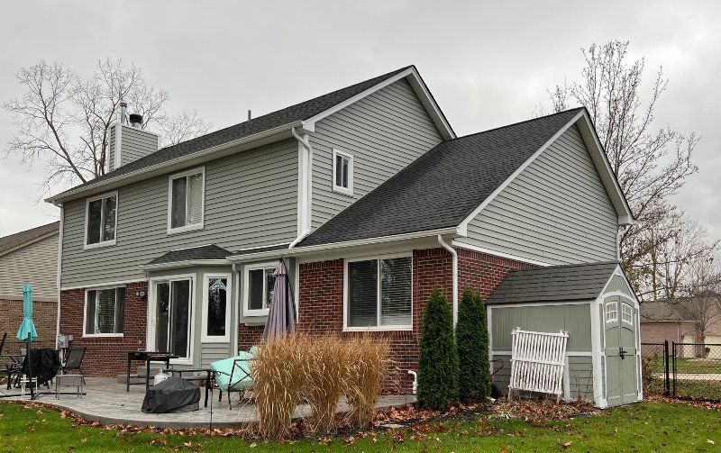 A large brick house with a shed in the backyard.