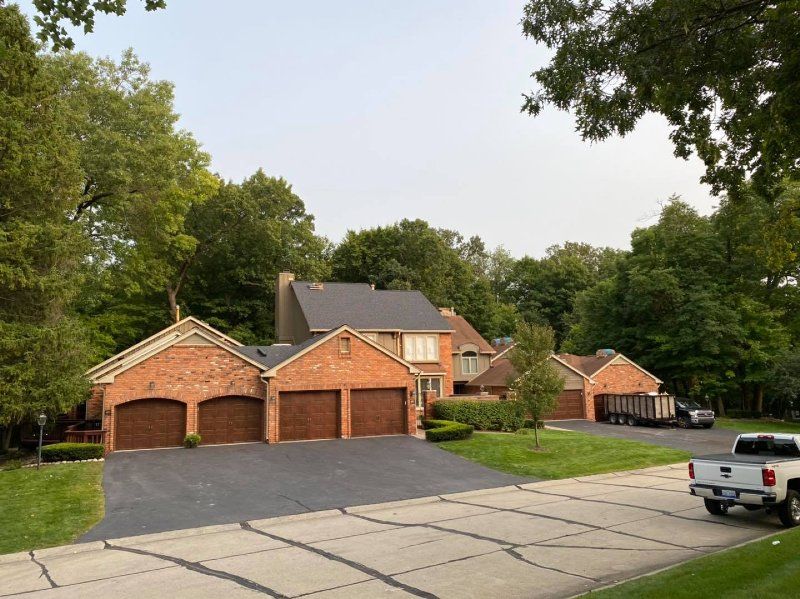 A truck is parked in front of a large brick house