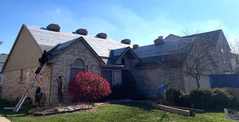 A brick house with a roof that is being installed.