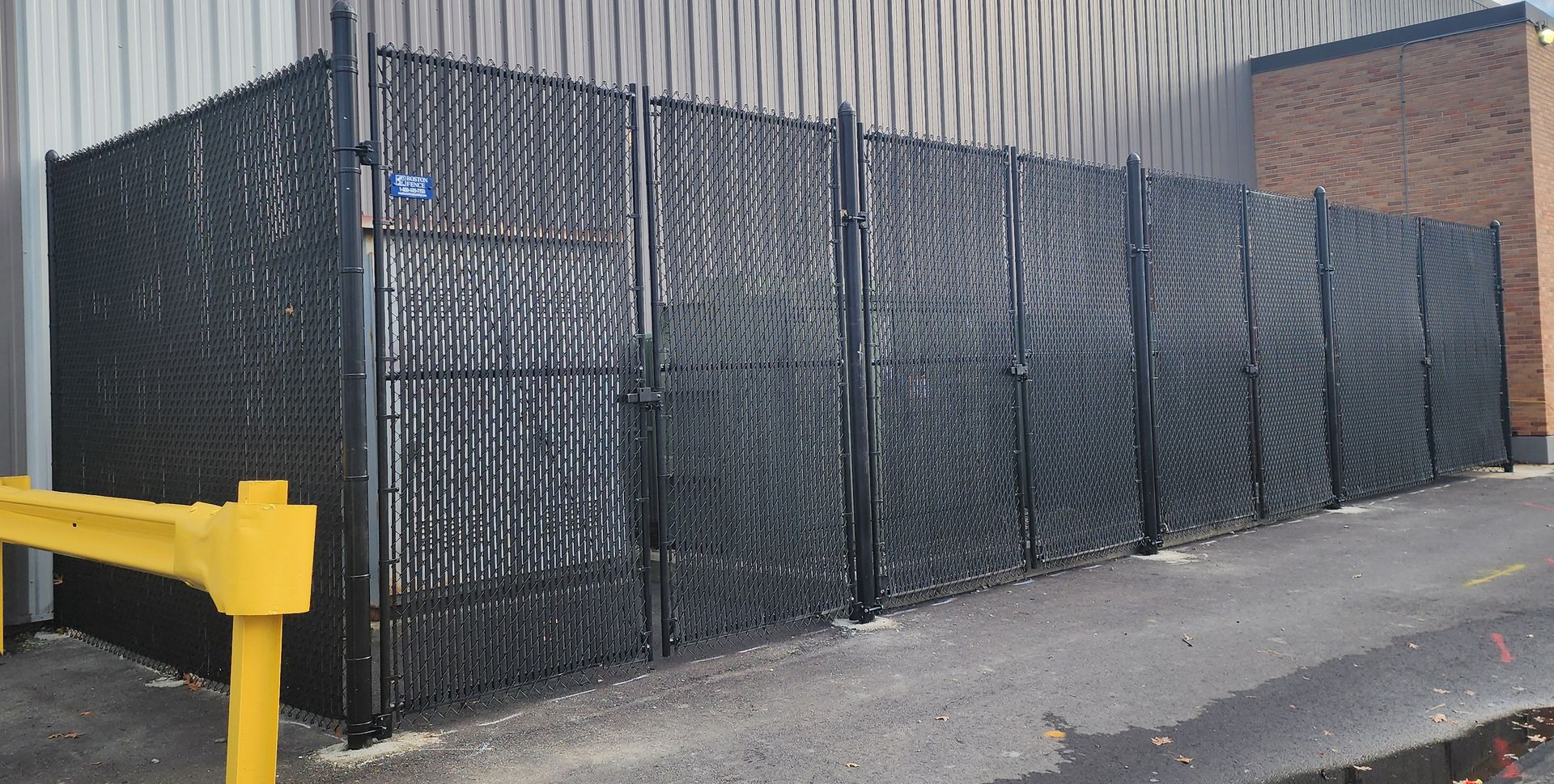 A black chain link fence is surrounding a building.