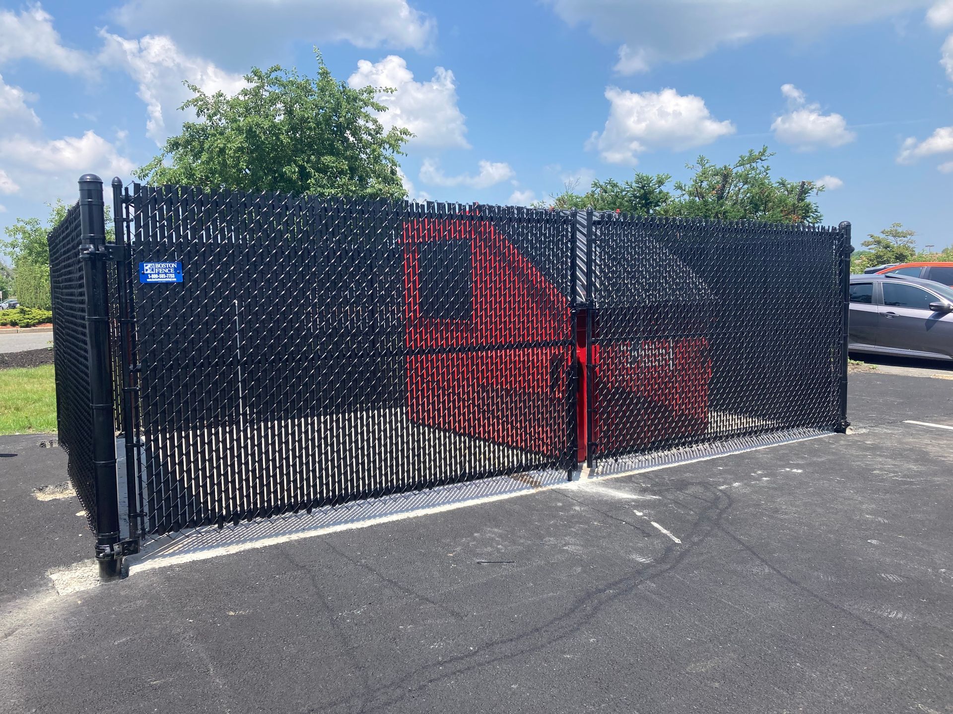 A black chain link fence is surrounding a parking lot.