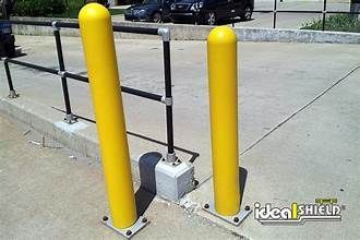 Two yellow poles are sitting next to each other on the sidewalk.