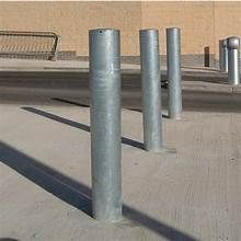 A row of metal poles sitting next to each other on a sidewalk.