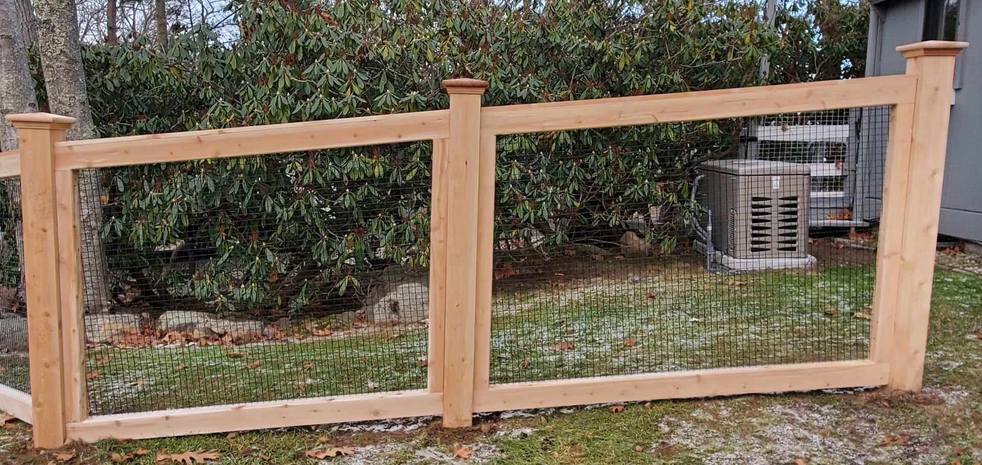 A wooden fence with a wire fence around it