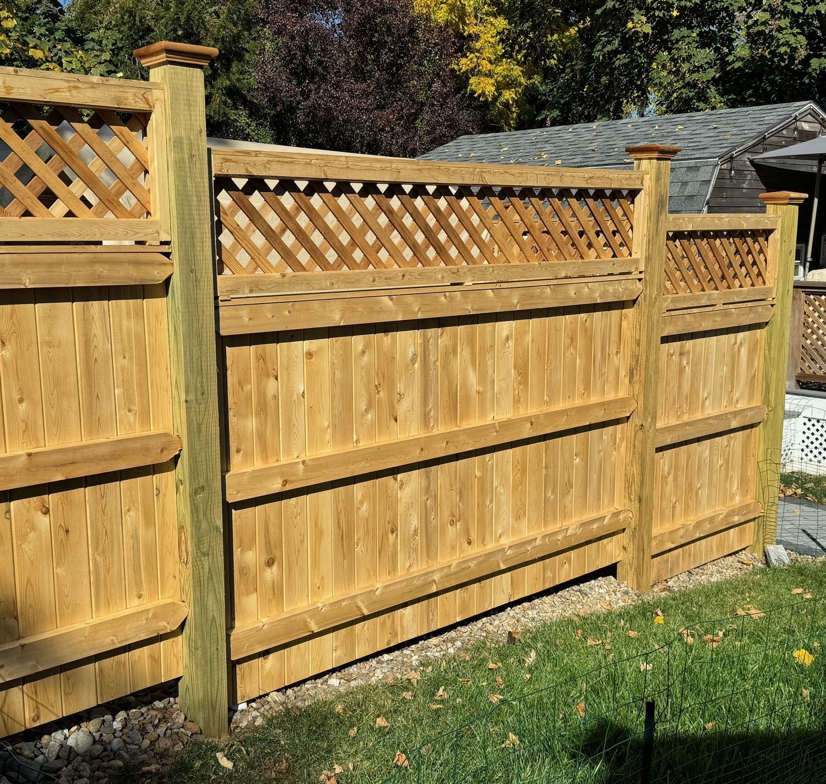 A wooden fence with a lattice on top of it
