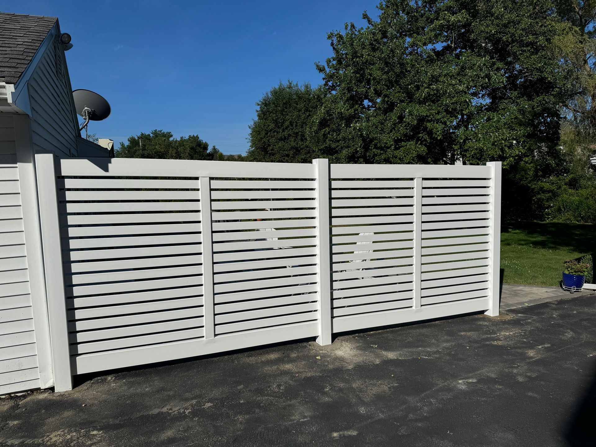 A white fence is sitting in front of a house