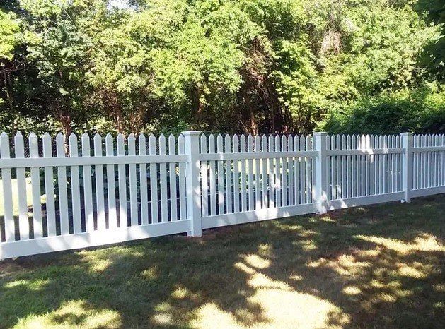 A white picket fence surrounds a lush green yard.