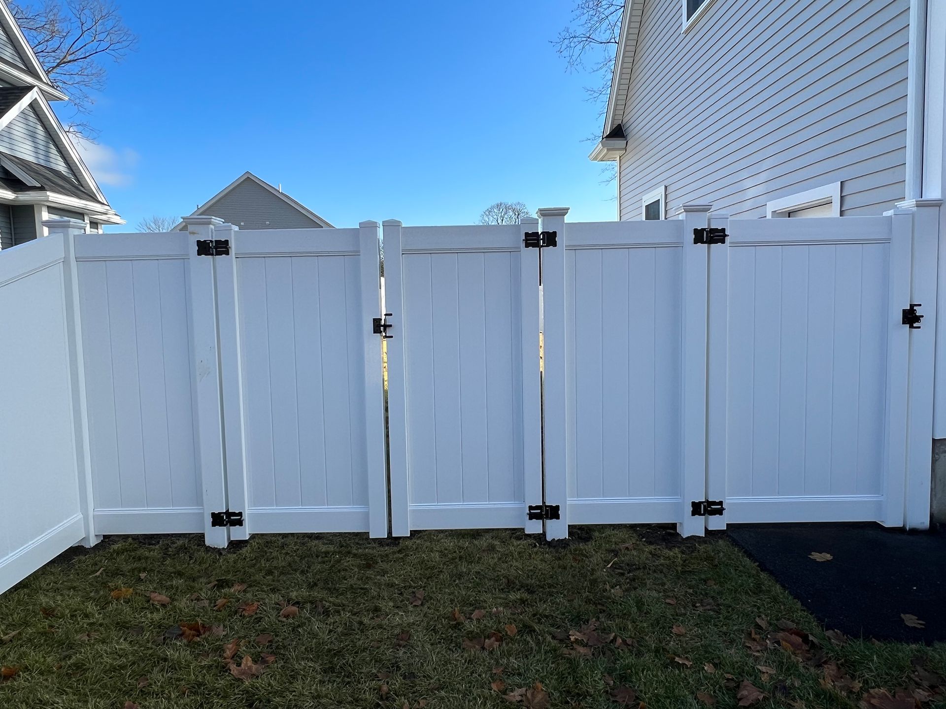 A white fence is sitting in front of a house.