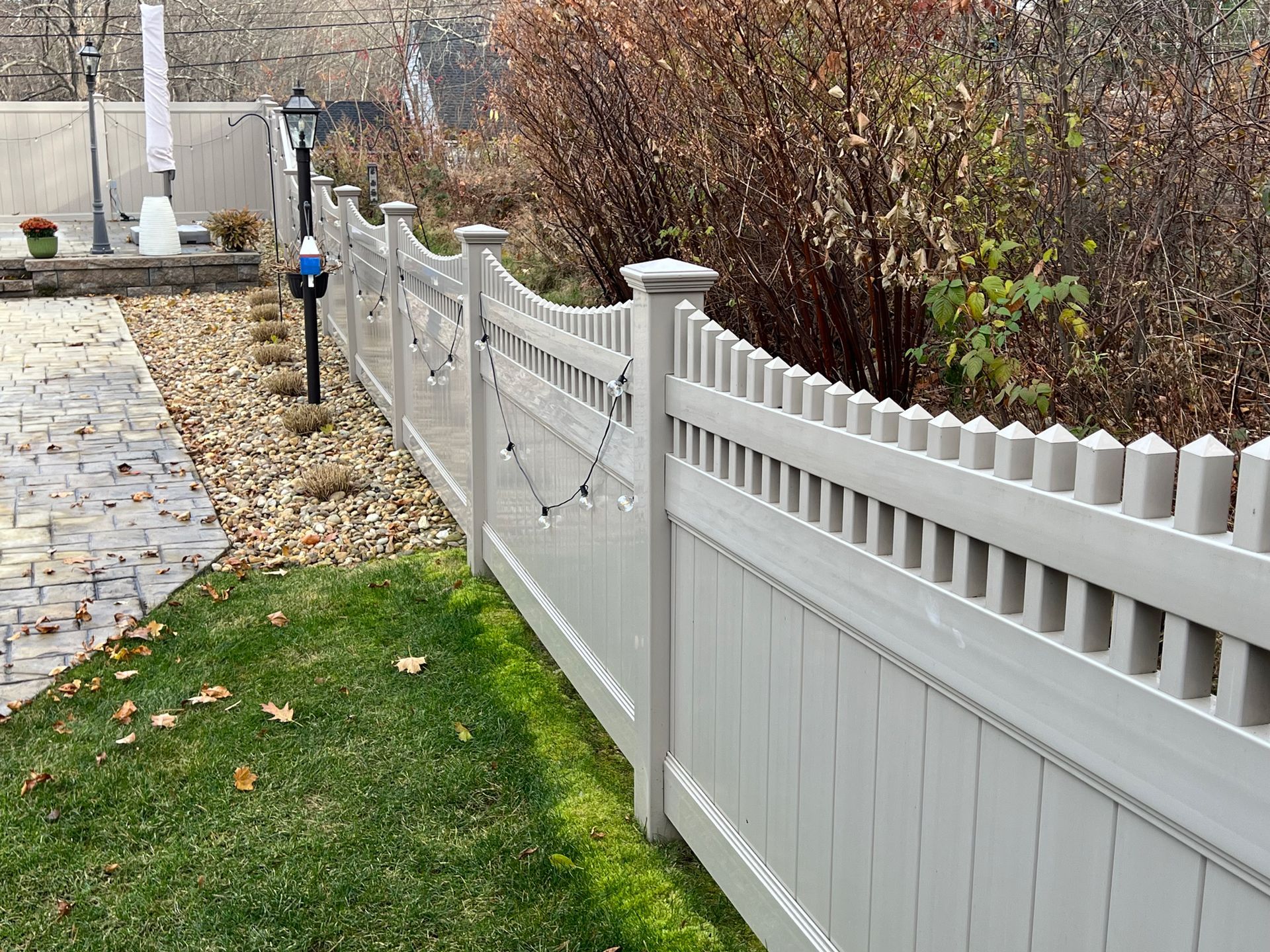 A white picket fence surrounds a lush green yard.
