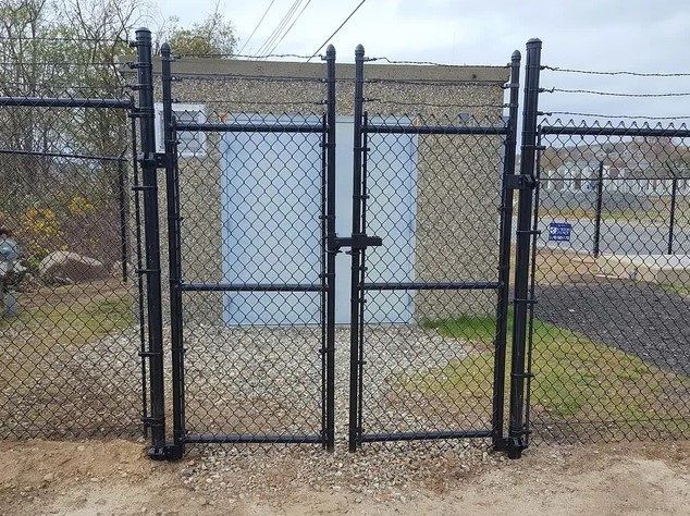 A chain link fence surrounds a building with a blue door