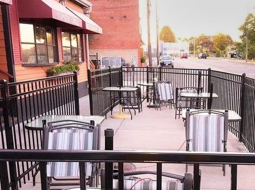 A patio with tables and chairs in front of a restaurant.