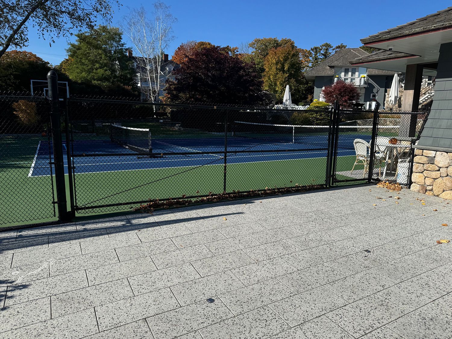 A tennis court is behind a chain link fence