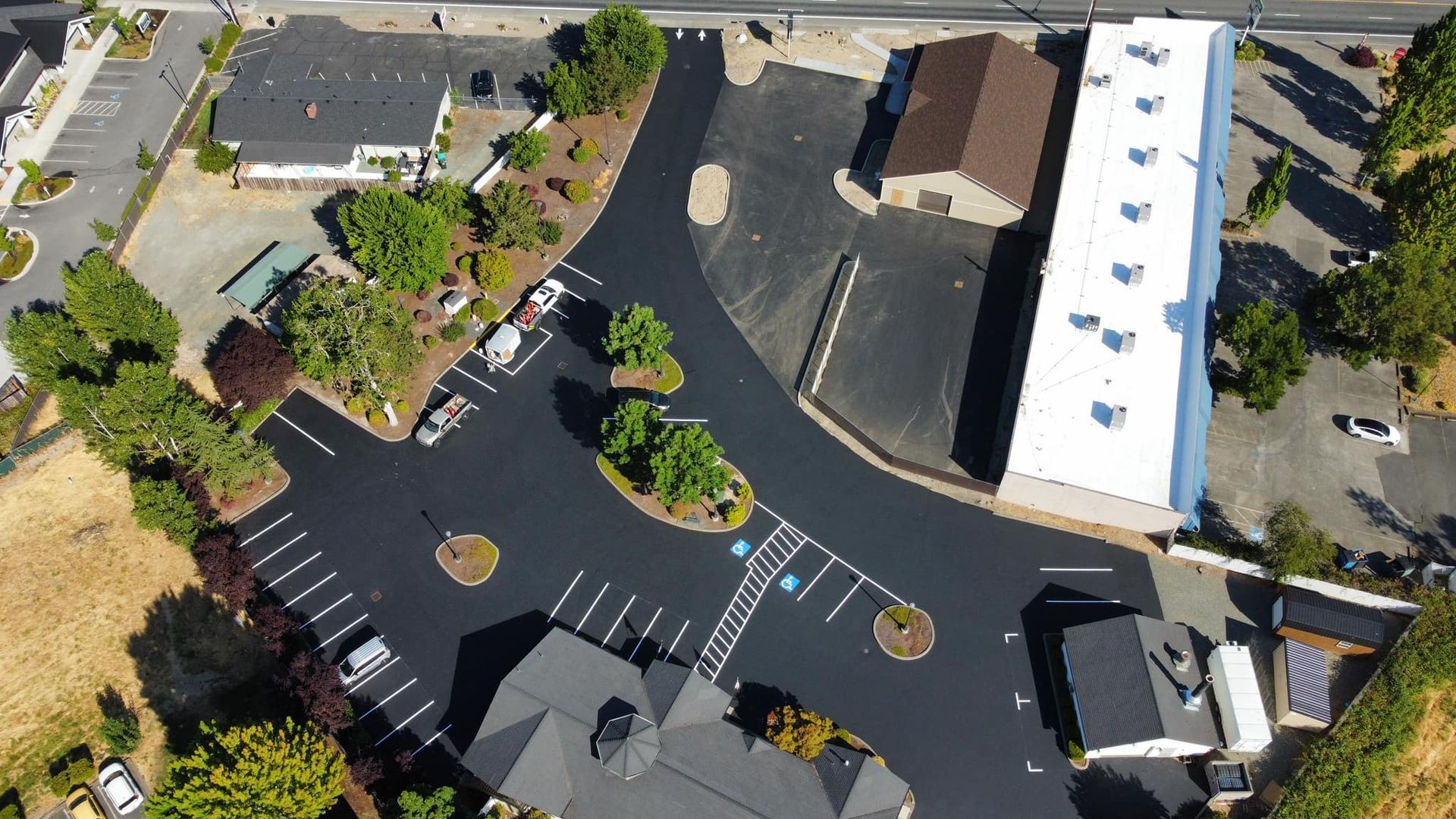 An aerial view of a parking lot with a building in the background