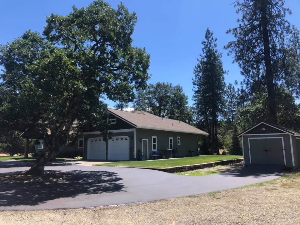 A house with a garage and a shed in front of it