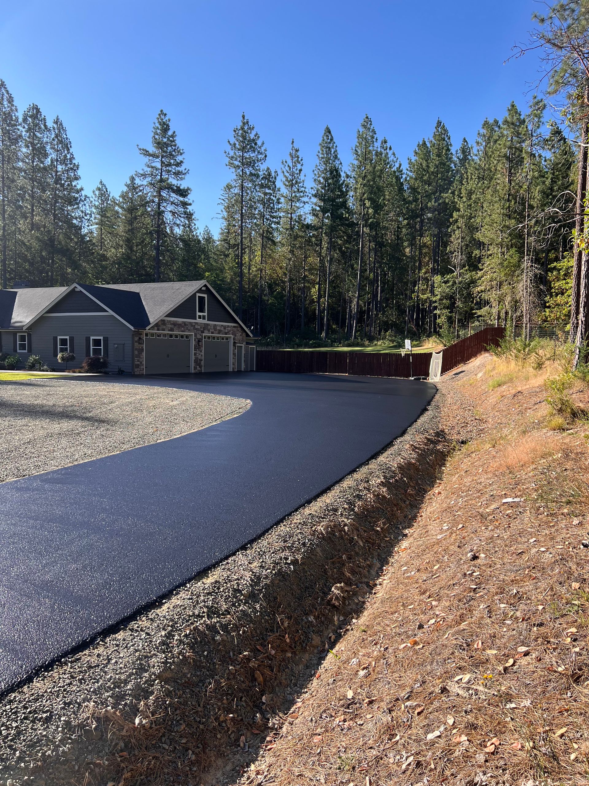 A driveway leading to a house with trees in the background.