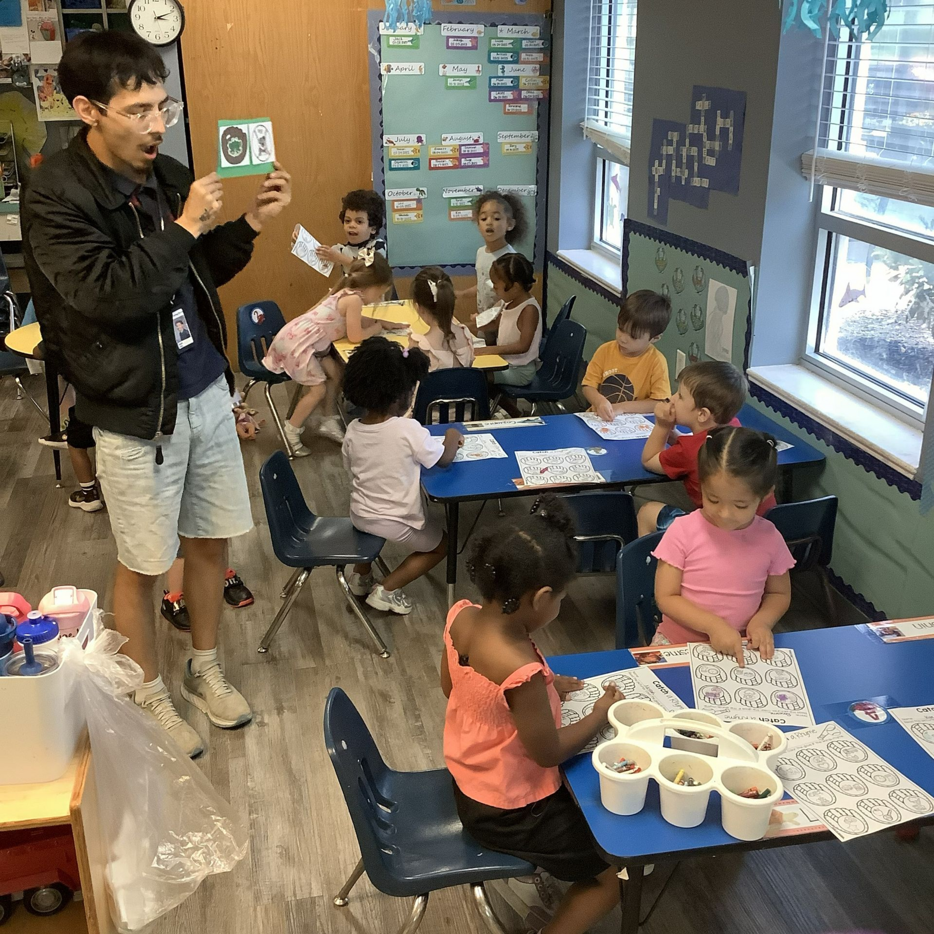 A group of children are playing in front of a bulletin board that says emotions