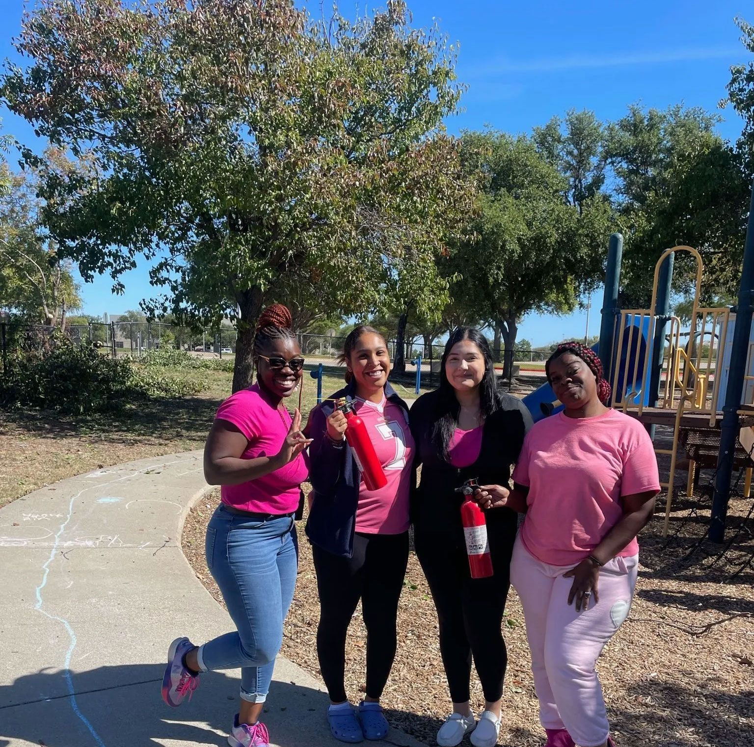 A group of women are posing for a picture in a park