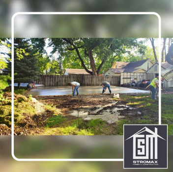 Workers smoothing a concrete slab outdoors. Green grass, trees, and houses in the background. Stromax logo in the bottom right.