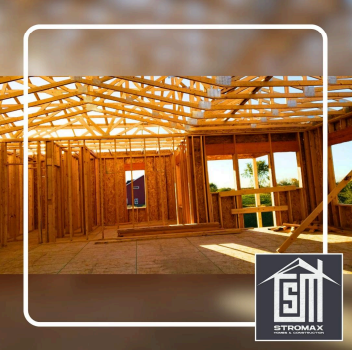 Interior framing of a house under construction; wooden beams and studs.