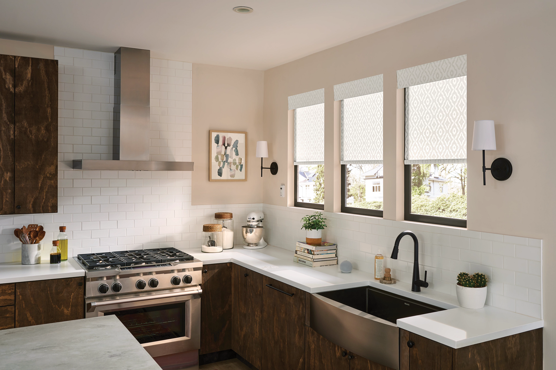 A modern kitchen with a stainless steel range, dark wood cabinets, and white countertops; windows with light shades.