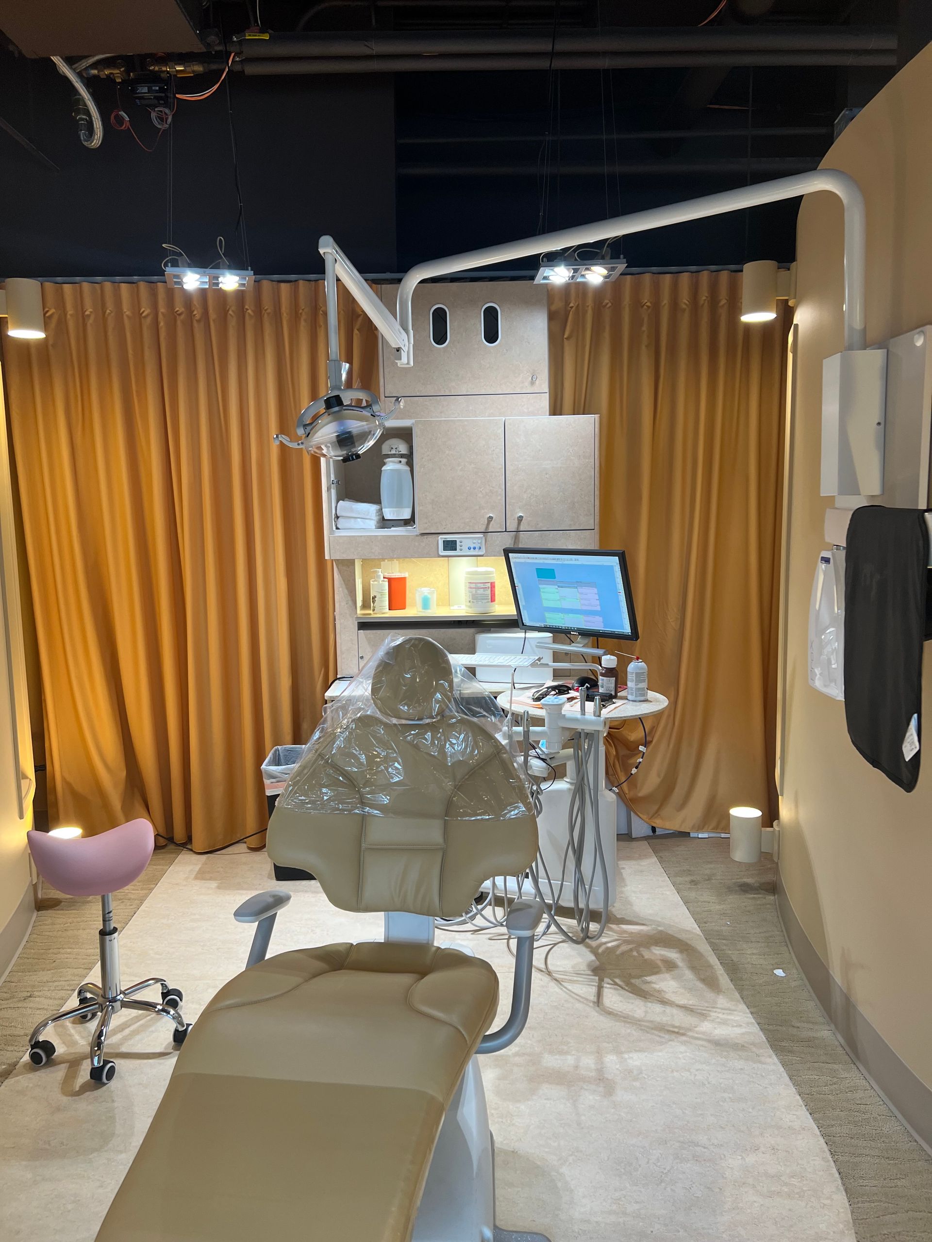 A dental office with a dental chair and a computer