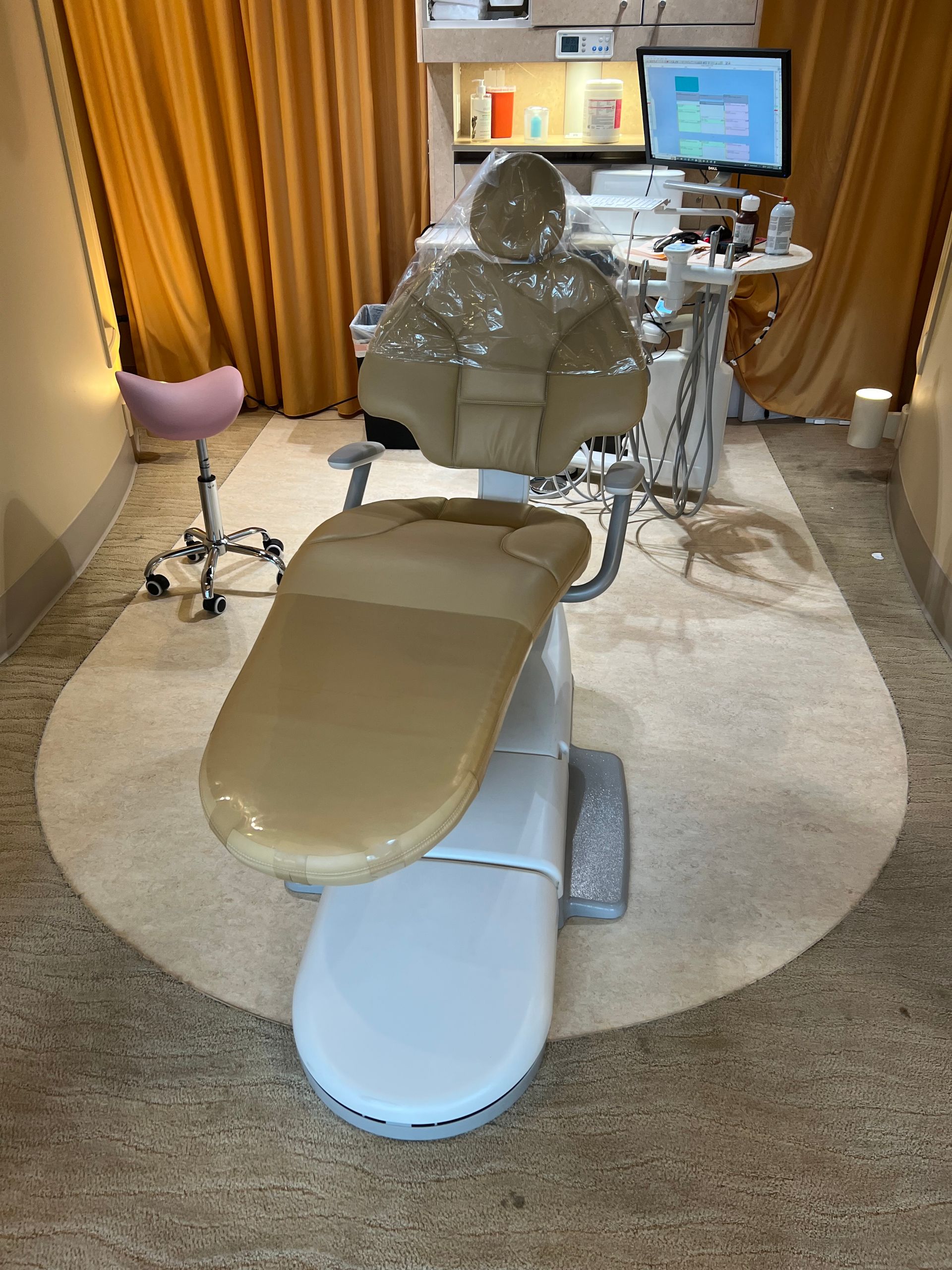 A dental chair is sitting in a dental office.