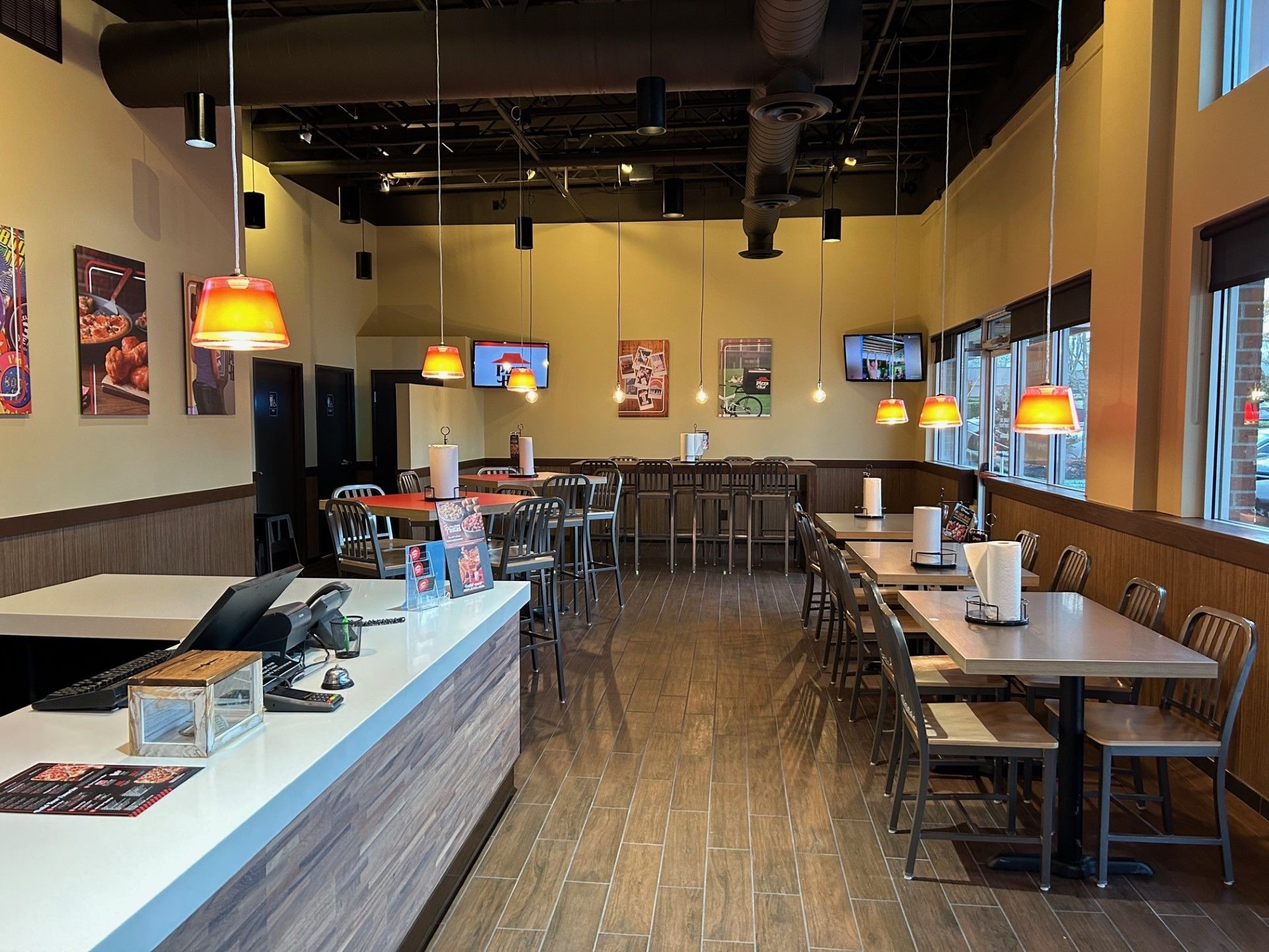 the inside of a restaurant with tables and chairs and a counter .