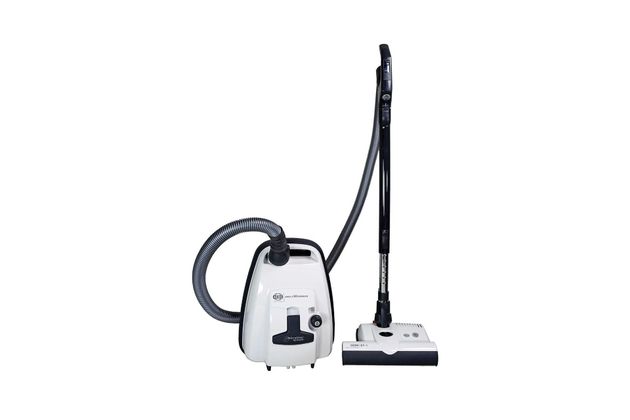 White canister vacuum cleaner with hose and floor brush attachment on a plain background