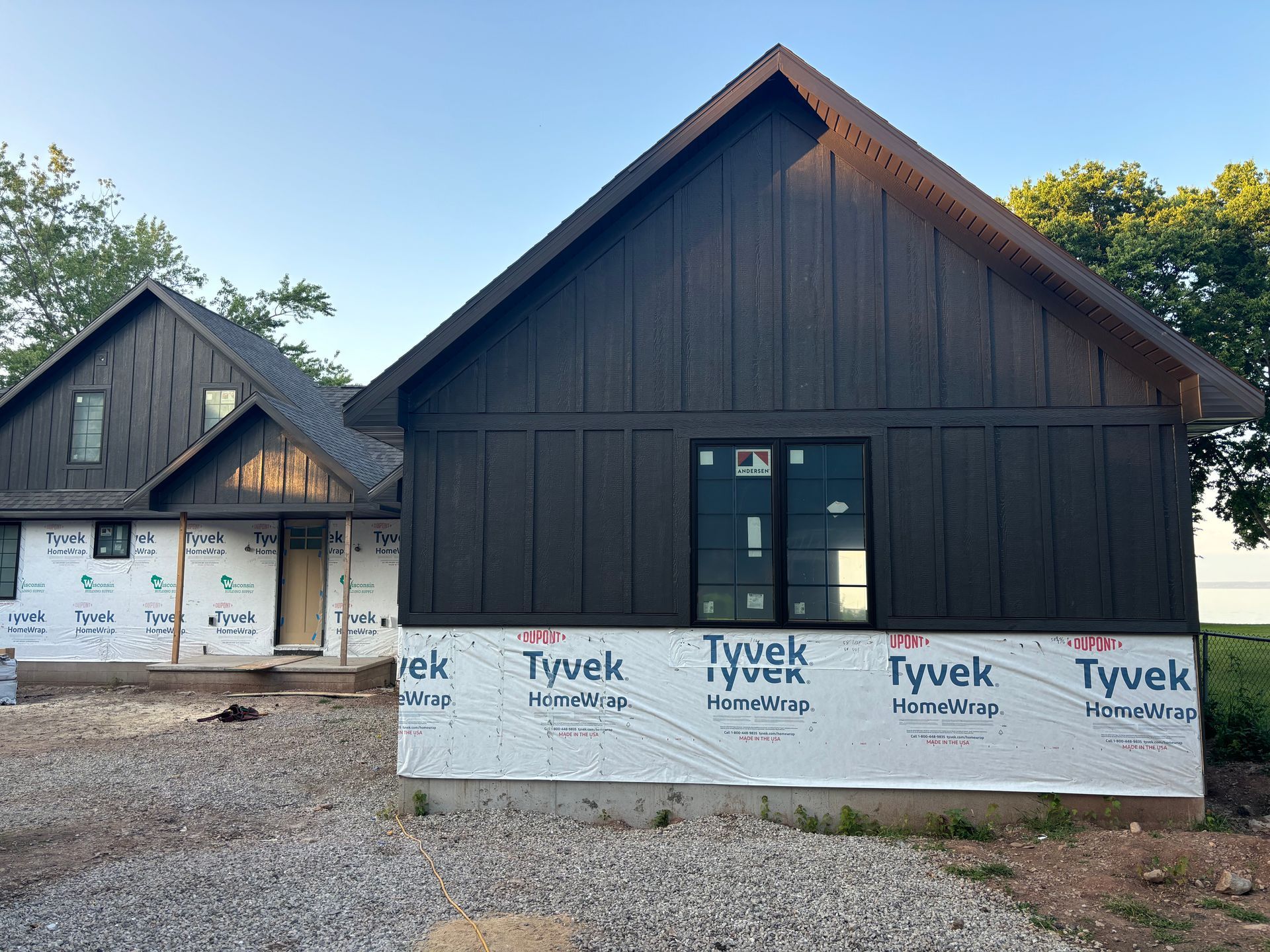 A house is being built with a black siding and black windows.