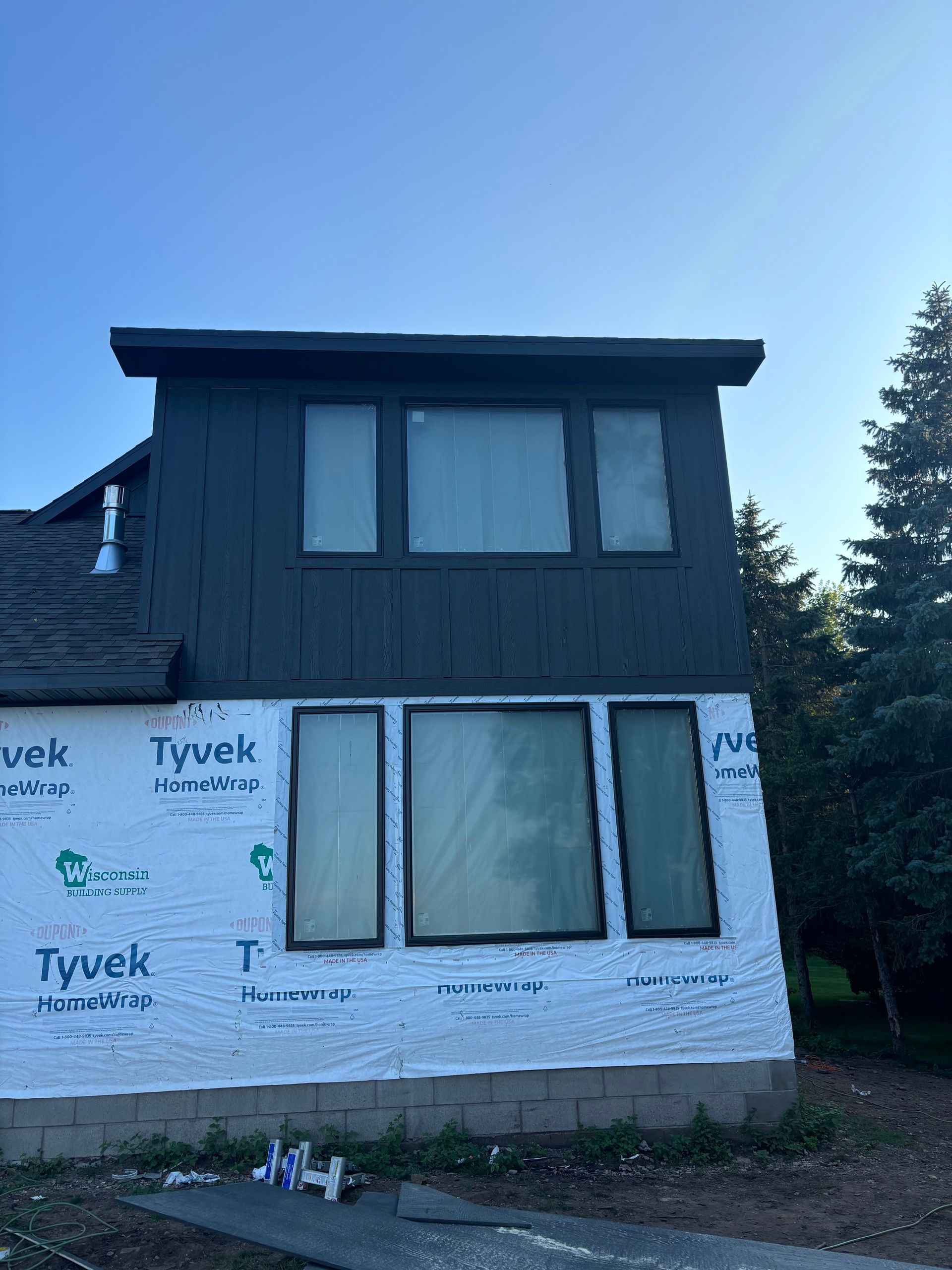 A house with a lot of windows and a blue sky in the background.
