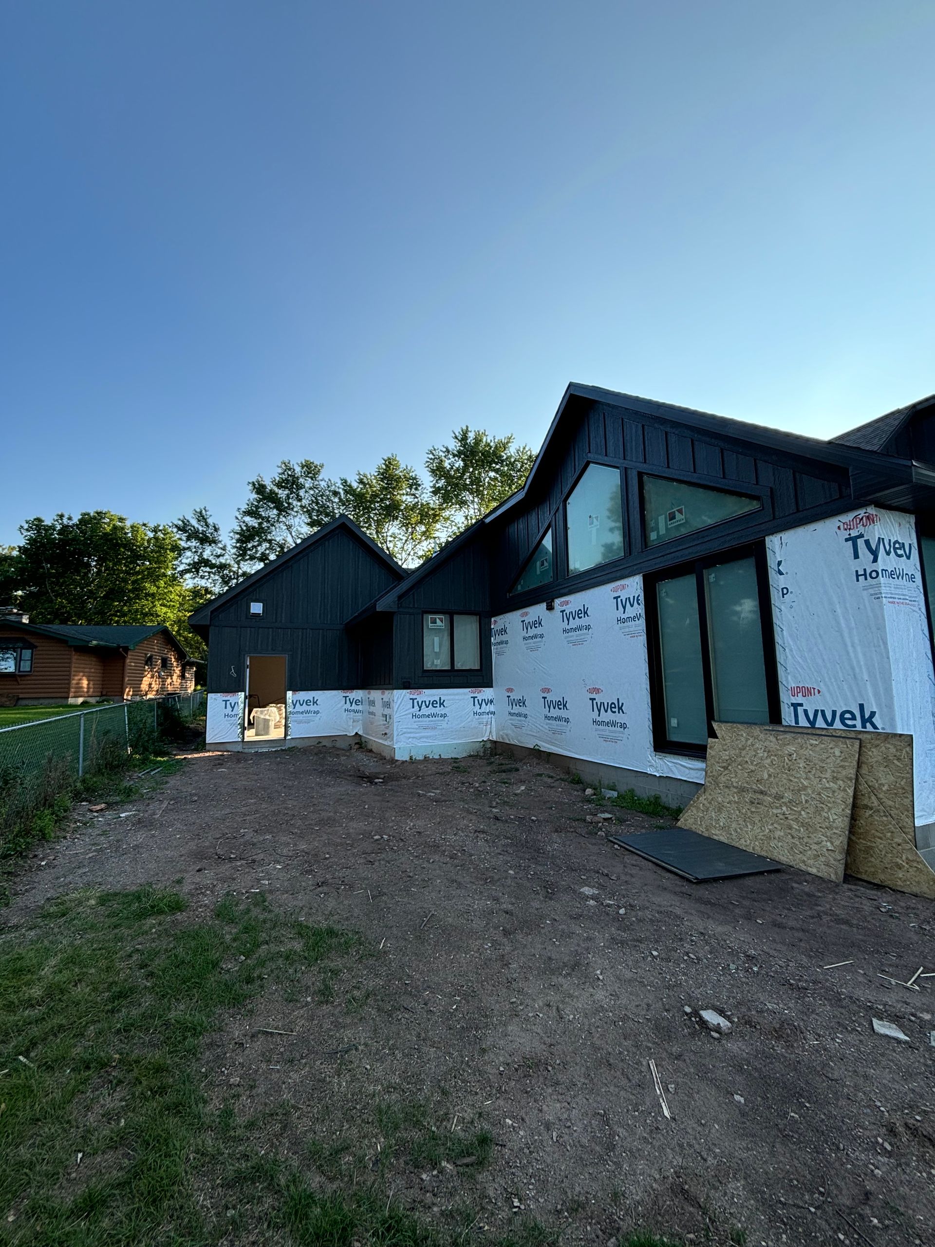 A house is being built in the middle of a dirt field.