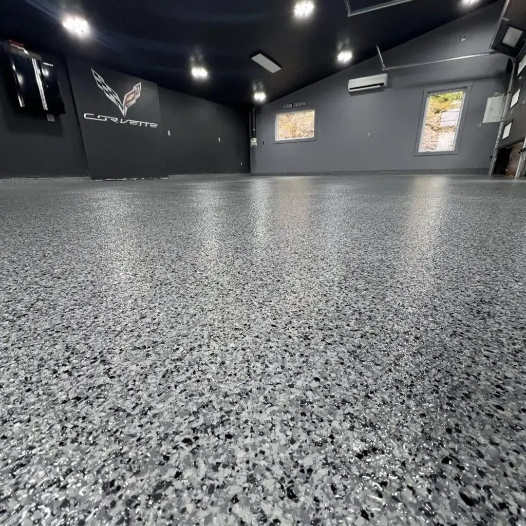 Empty black gym with speckled gray flooring and wall posters