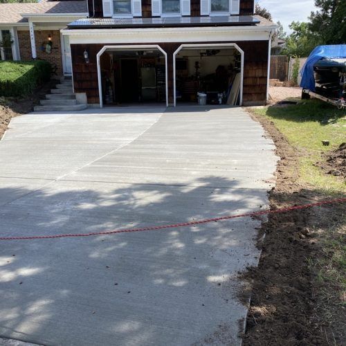 A concrete driveway is being built in front of a house.