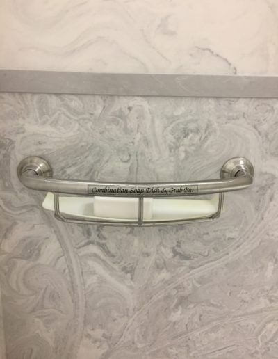 A soap dish is hanging on a wall in a bathroom.