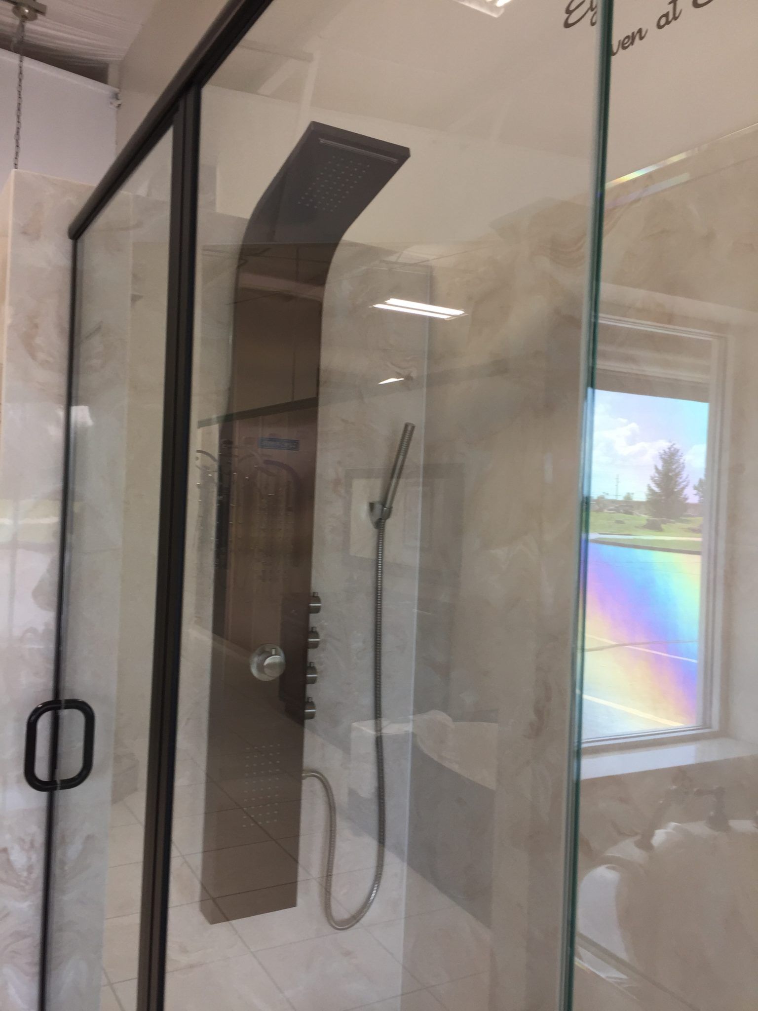 A shower stall with a stainless steel shower head in a bathroom.