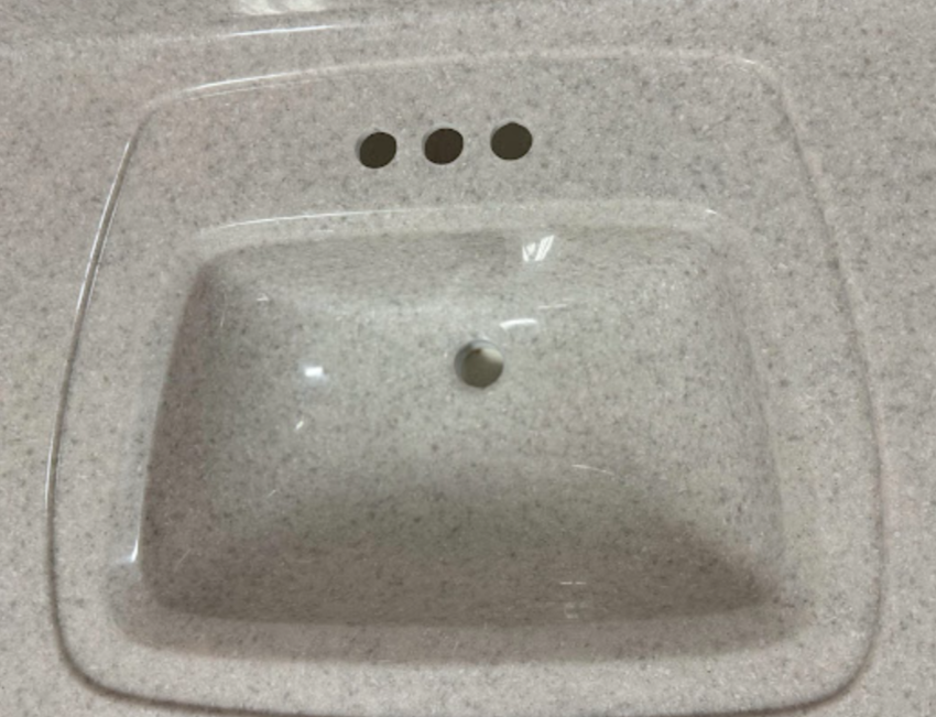 A bathroom sink with three holes in it