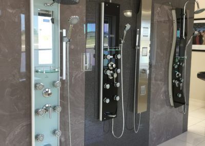 A bathroom with a row of shower heads on the wall.