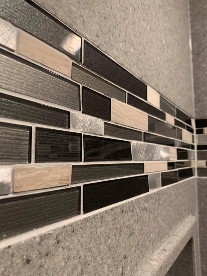 A close up of a tile wall in a bathroom.