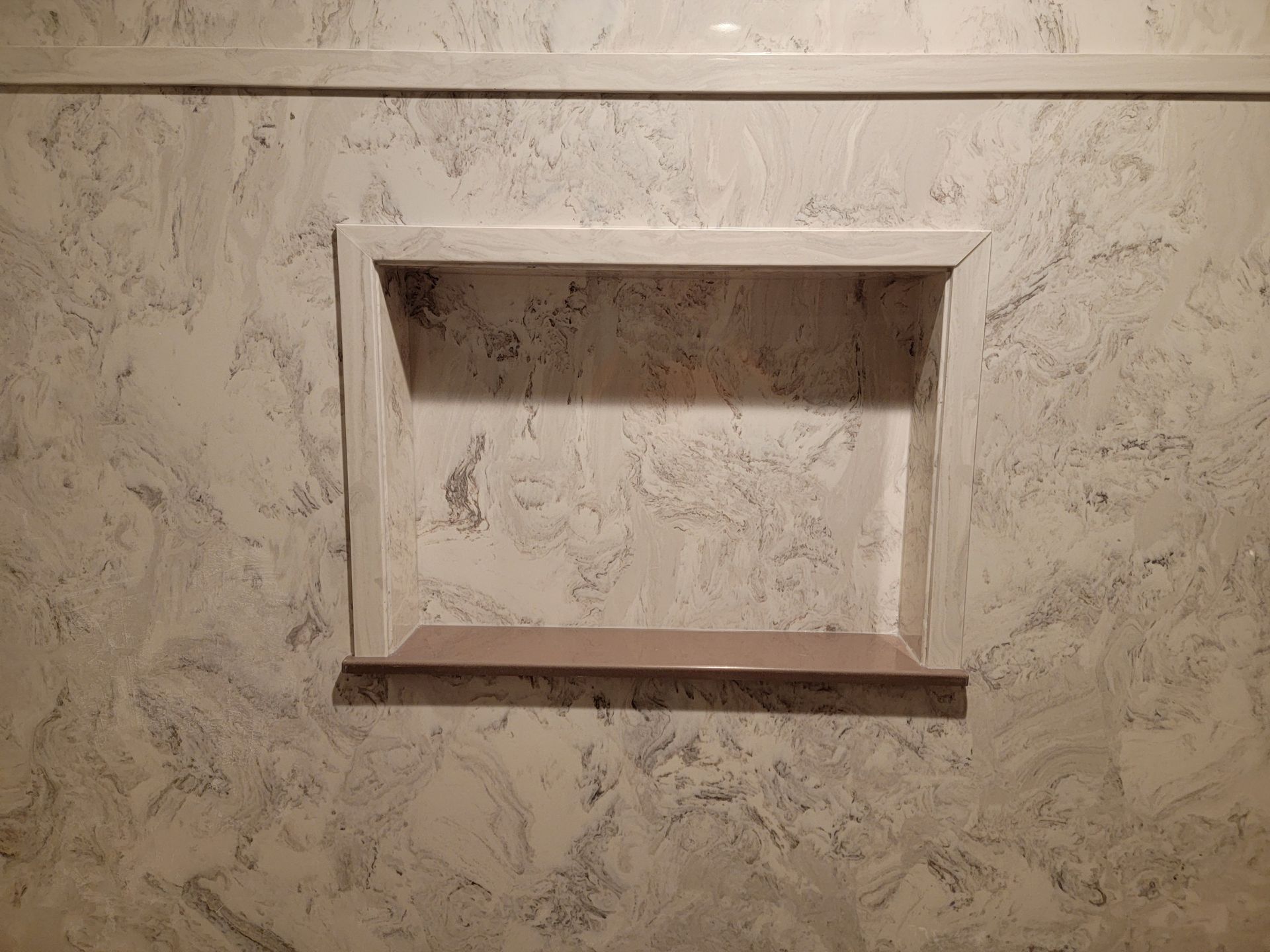 A shower niche is built into the wall of a bathroom.