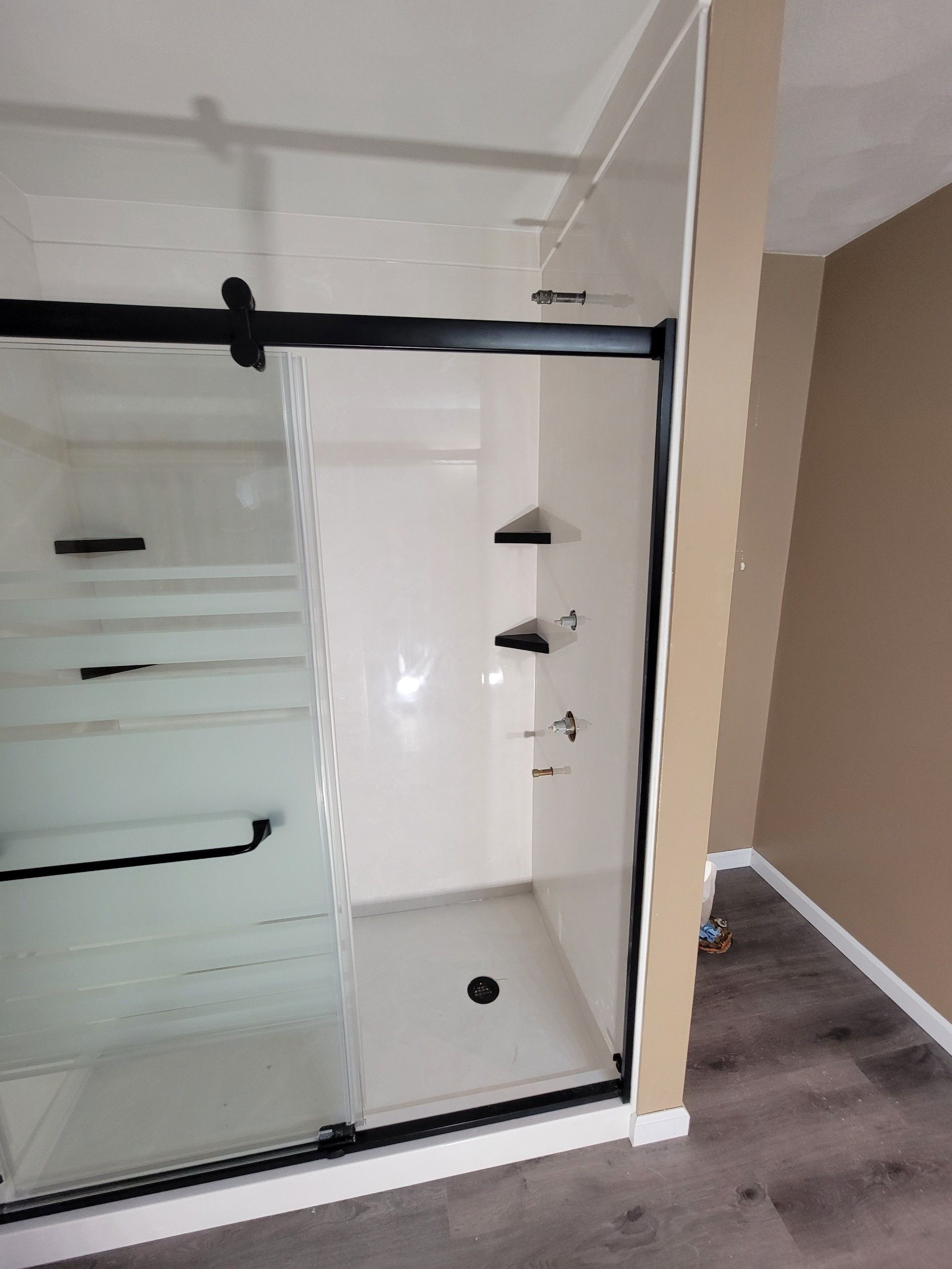 A bathroom with a sliding glass shower door.