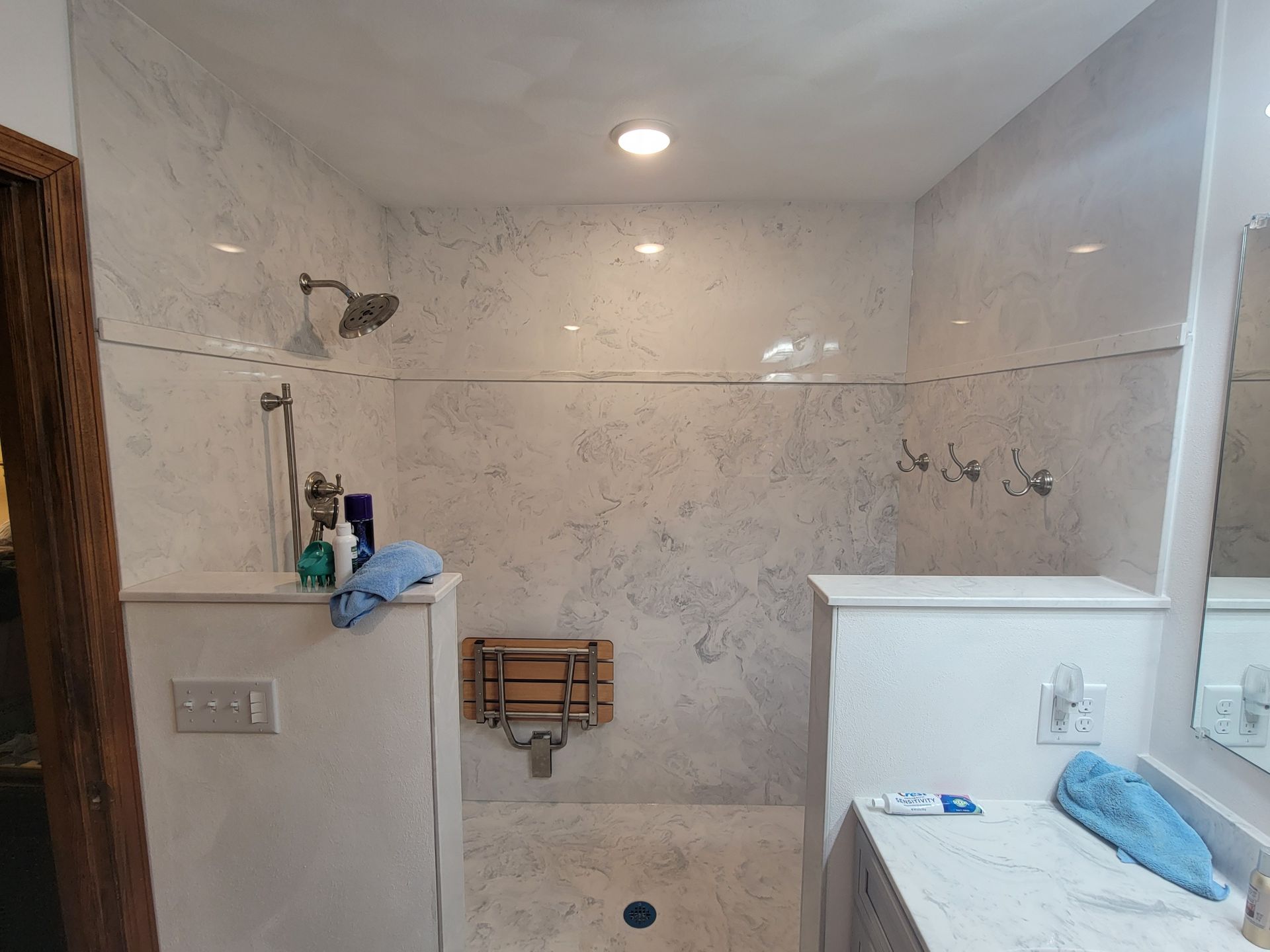 A bathroom with a walk in shower and a sink.