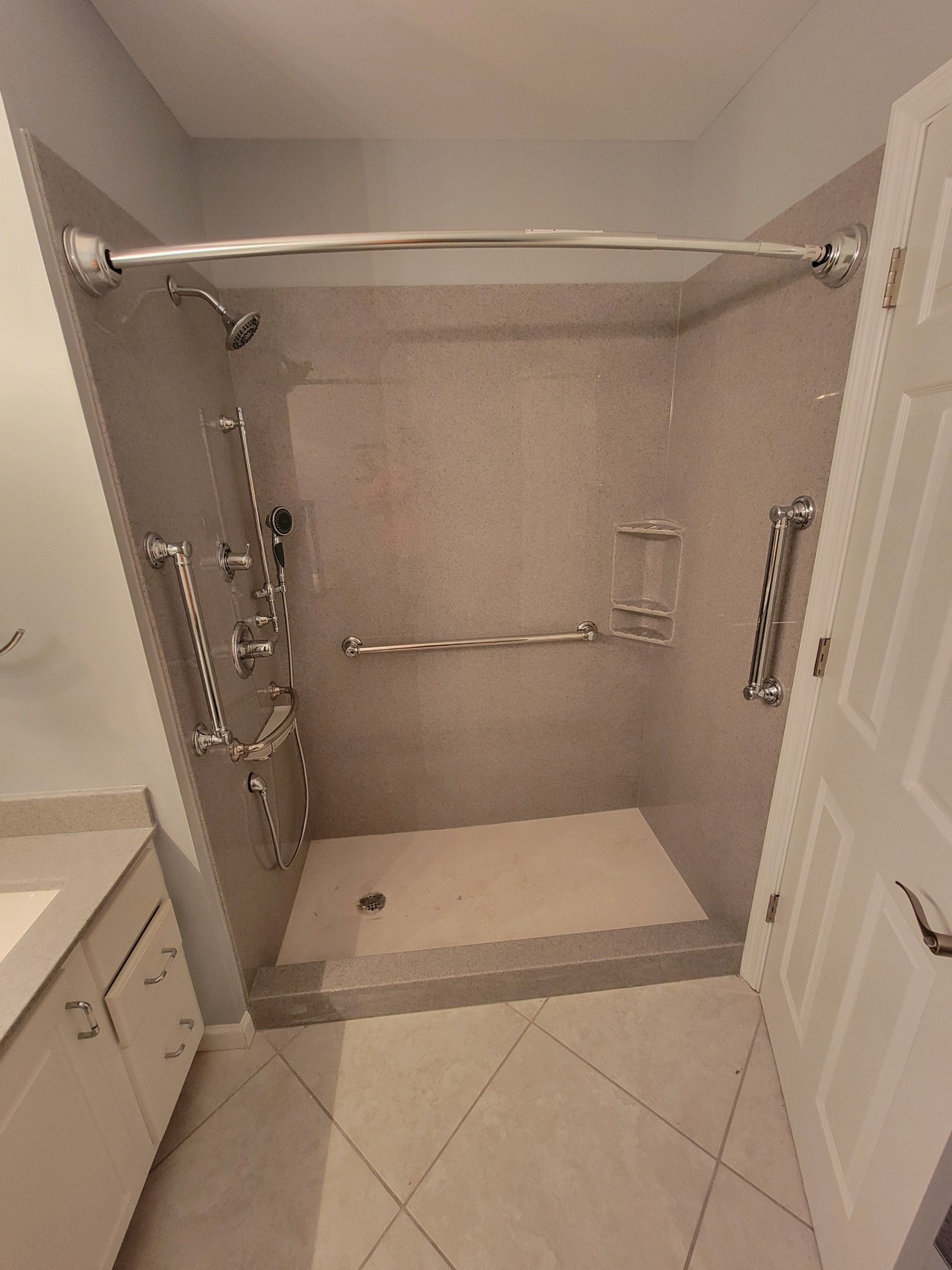 A bathroom with a walk in shower and a sink.