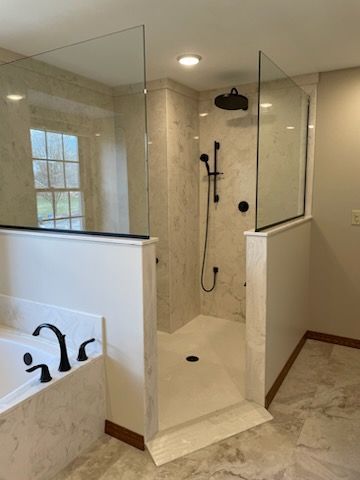 A bathroom with a walk in shower and a bathtub.