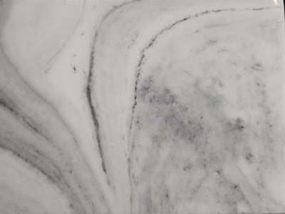 A close up of a white marble tile with a swirl pattern.