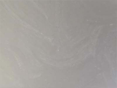 A close up of a white tile with a gray marble texture.