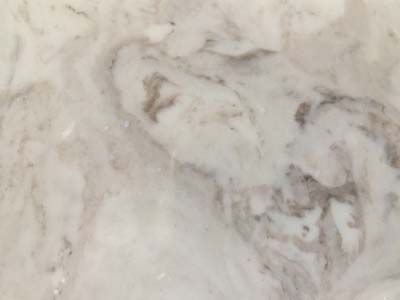 A close up of a white marble counter top with a swirl pattern.