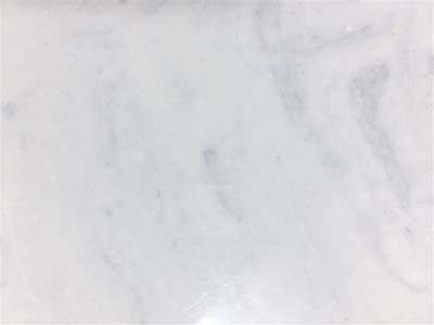 A close up of a white marble tile with a marble texture.